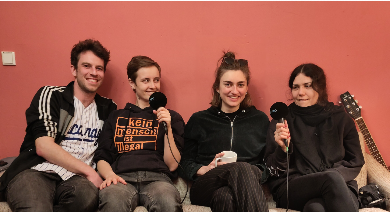 Das Foto zeigt die vier Mitglieder der Band Kapa Tult, die auf einem Sofa im MUZclub sitzen.