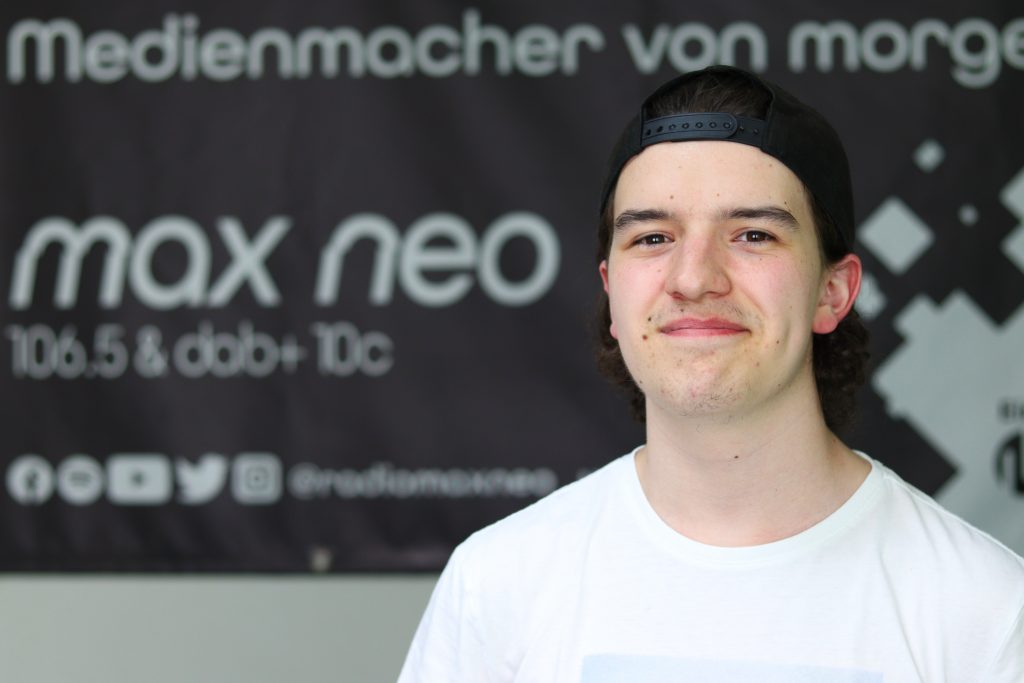Das Foto zeigt Silas Urban im Porträt vor dem max neo Banner.