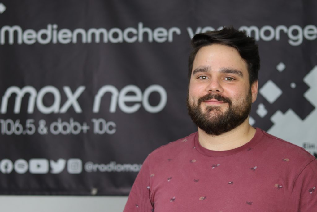 Das Foto zeigt Tobias Godenberg im Porträt vor dem max neo Banner.