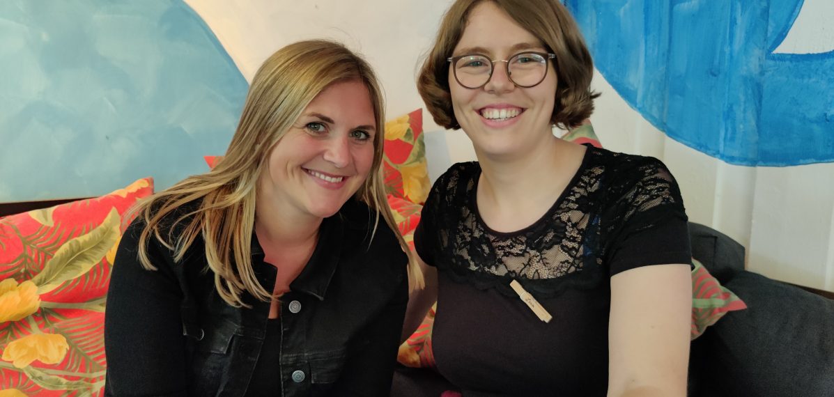 Das Foto zeigt die Autorin Lilly Lucas und die max neo Moderatorin Lena Schnelle, die zusammen auf einem Sofa einer Beach Bar sitzen.
