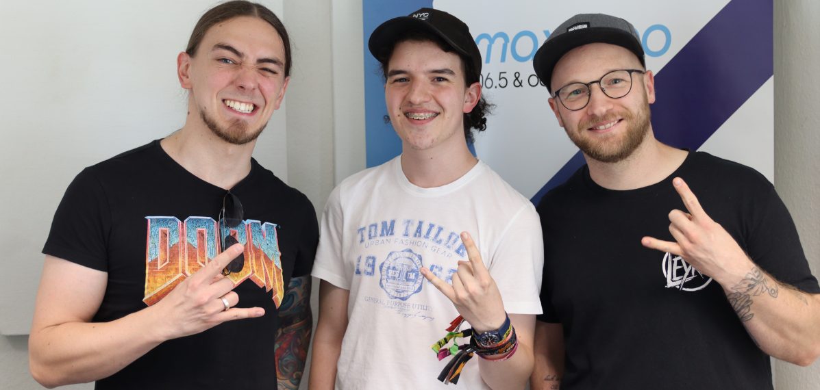 Das Foto zeigt Chris und Gordy von Torrential Rain mit max neo Moderator Silas Urban.