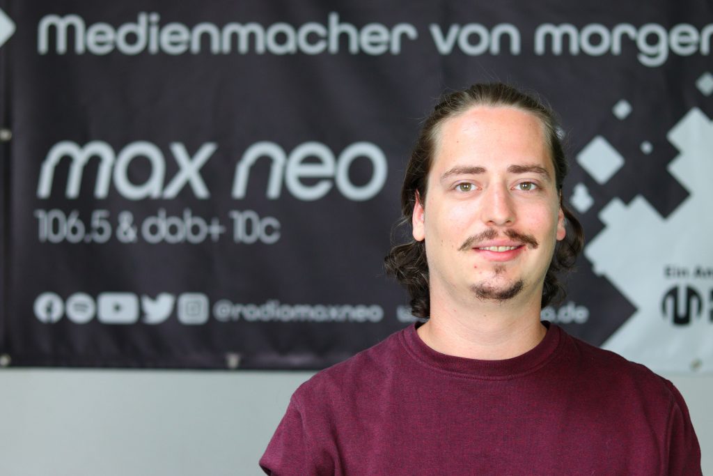 Das Foto zeigt Lars Eberhard im Porträt vor dem max neo Banner.