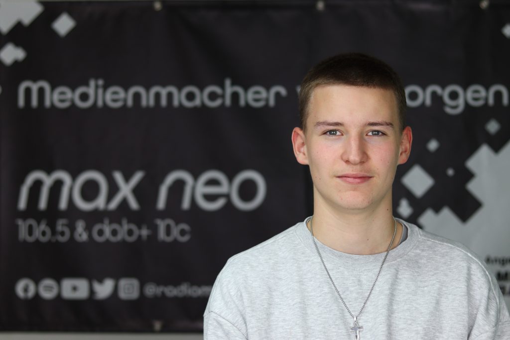 Das Foto zeigt Emil Helbig im Porträt vor dem max neo Banner.