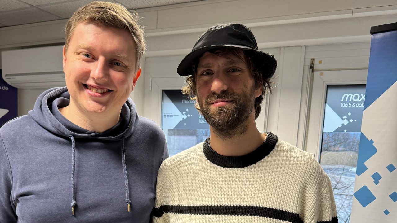 Das Foto zeigt den Musiker Michi von der Band LIONLION und Moderator Moritz im max neo Studio.